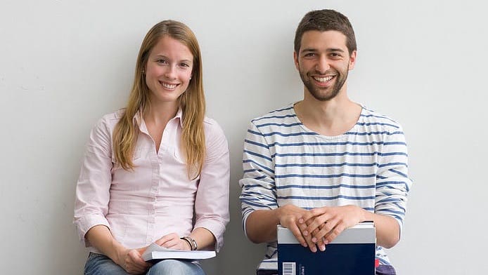 Two adult students with their Spanish course books